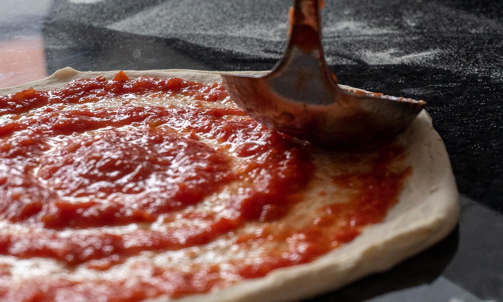 La sauce tomate étalée sur la pâte